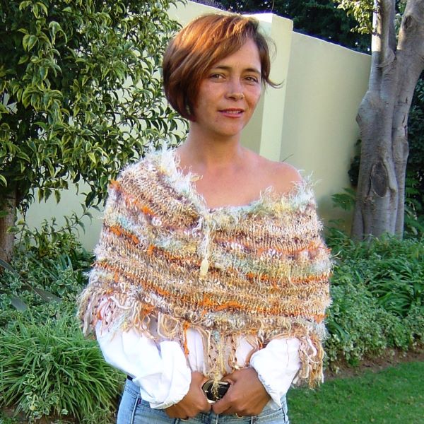 Shoulder shrug knit from kid mohair worn by model standing in a garden