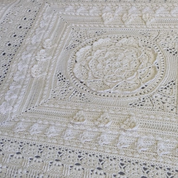 Close up of the centre medallion of Mixology Edition 6 by Hooked on Sunshine, worked in cream Cotton Scintilla DK, showing layered petal texture surrounded by lace and bobble stitch borders in a square layout