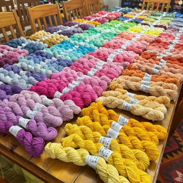 Dozens of hand dyed cotton yarn skeins in a full spectrum of colours laid out on a table in the ColourSpun studio, South Africa